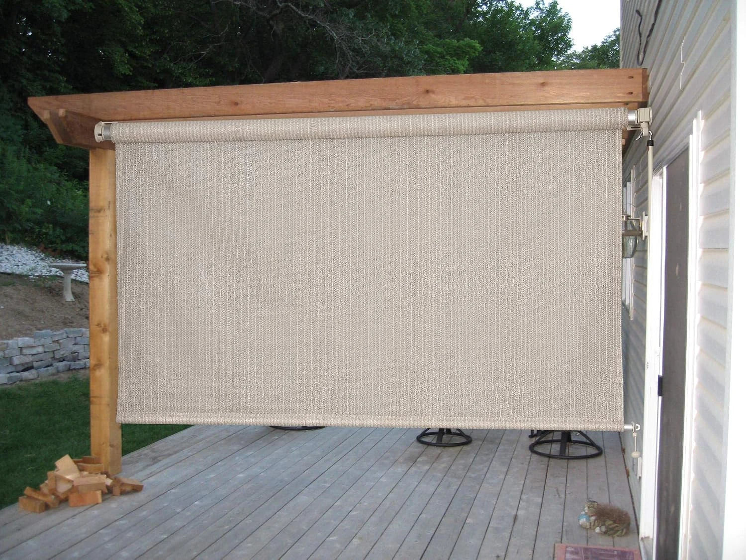Beige outdoor roller shade installed on a patio